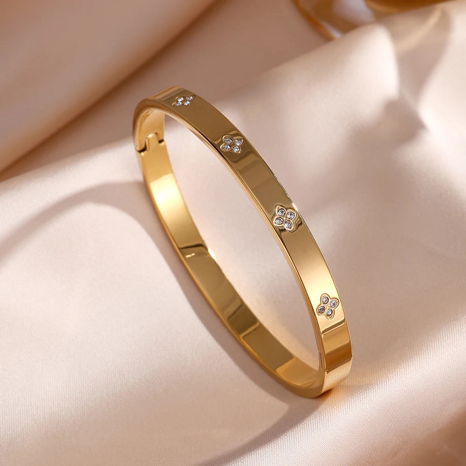 Gold bracelet with diamond accents on a beige fabric background