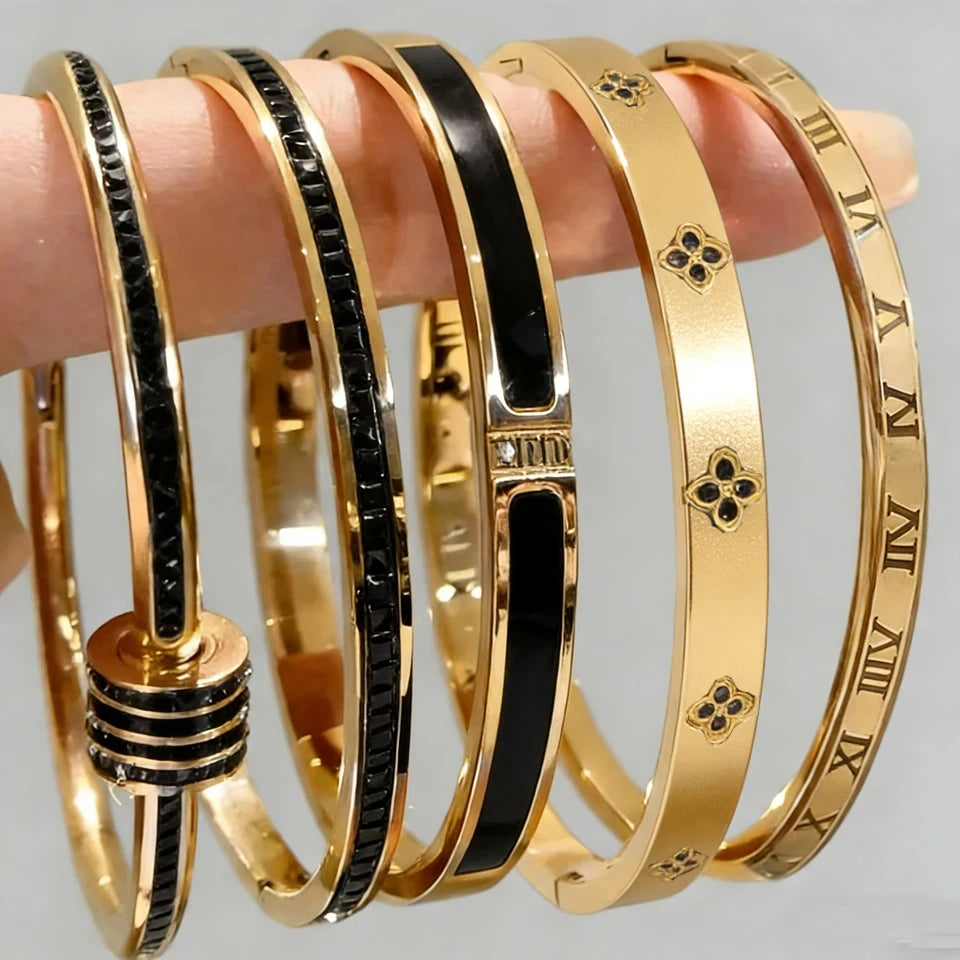 Set of gold and black bangles on a gray background