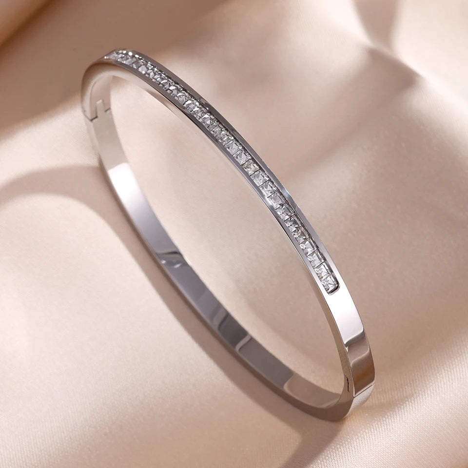 Silver bracelet with embedded diamonds on a beige fabric background